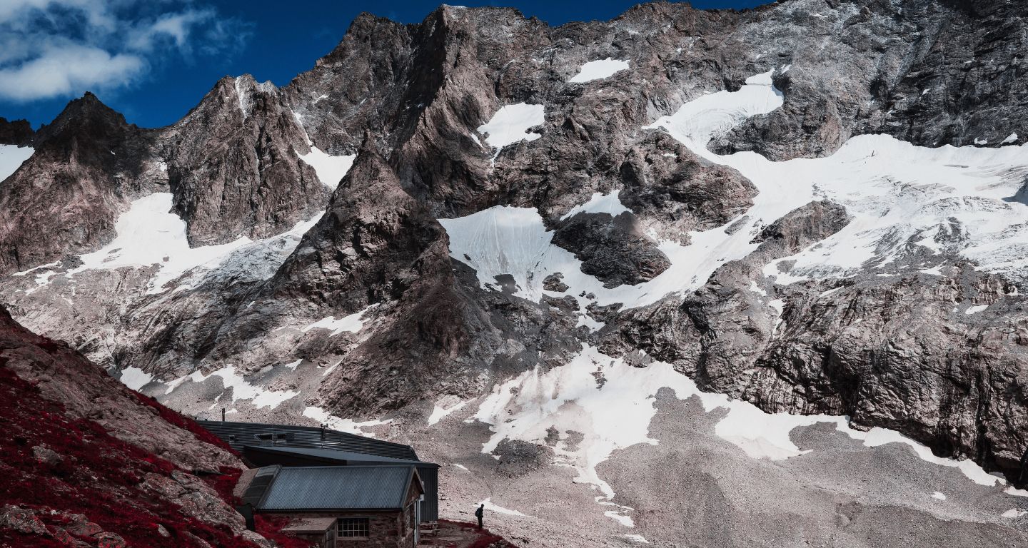 Un excursionista observa el paisaje desde el refugio de la Selle en el macizo de Ecrins en Saint-Christophe-en-Oisans, el 8 de julio de 2025. [Foto: Jeff Pachoud/AFP]