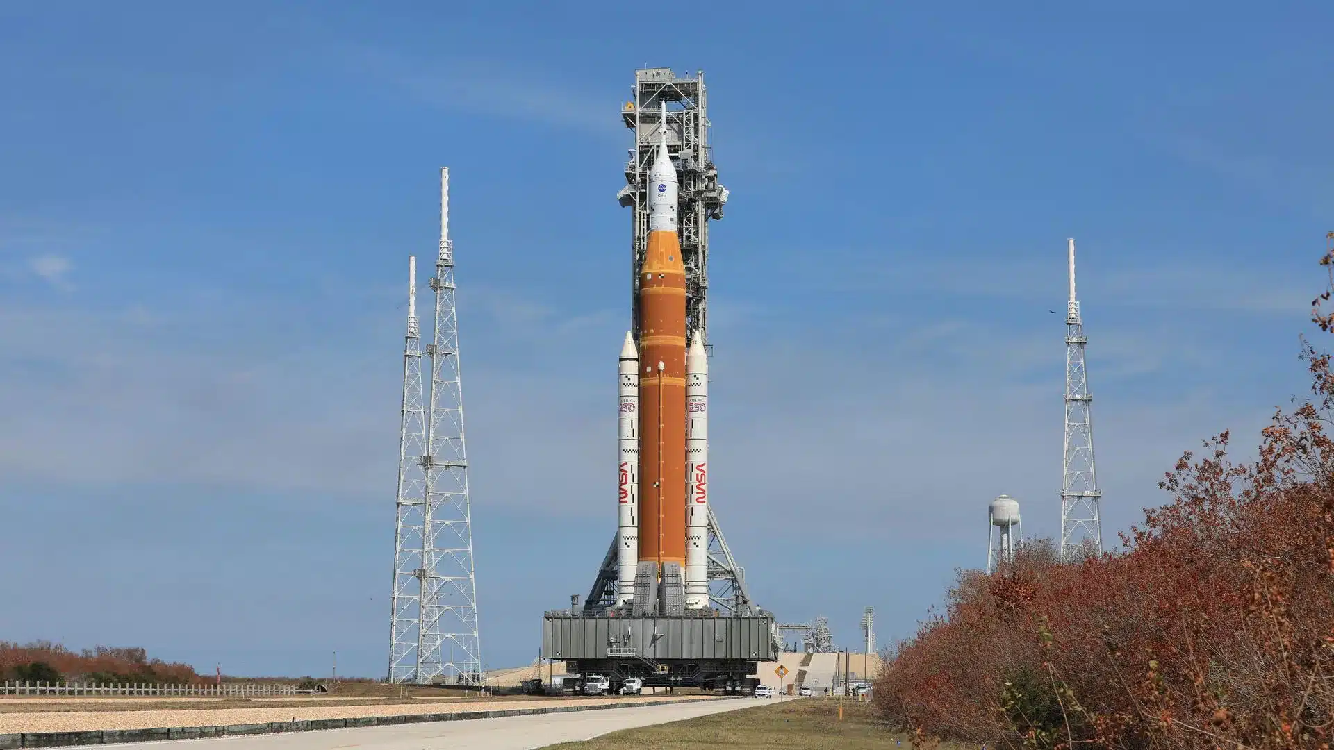 El transportador de orugas 2 de la NASA, que transporta el cohete Artemis II SLS (Sistema de Lanzamiento Espacial) con la nave espacial Orión fijada al lanzador móvil 1, regresa el miércoles 25 de febrero de 2026 al Edificio de Ensamblaje de Vehículos del Centro Espacial Kennedy de la NASA en Florida para solucionar problemas con el flujo de helio a la etapa superior del cohete, la etapa de propulsión criogénica provisional. [Foto: NASA/Kim Shiflett]
